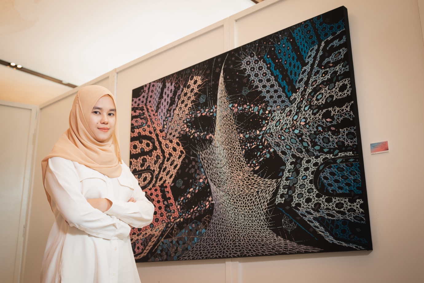 Mariem Chantachua in front of one of her embroidery artworks.