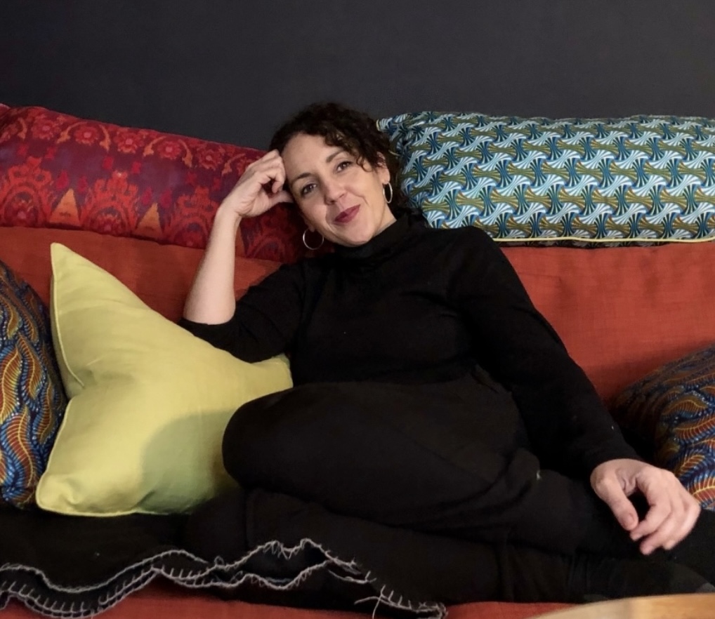 Author Angie Cruz on a sofa