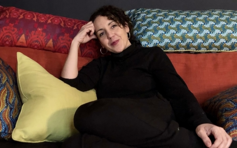 Author Angie Cruz on a sofa
