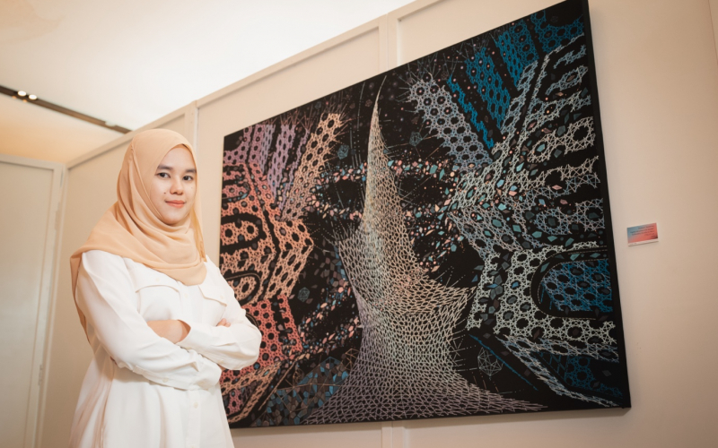 Mariem Chantachua in front of one of her embroidery artworks.